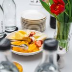 An elegant dining setup featuring fresh fruits and vibrant tulips, perfect for a healthy meal.